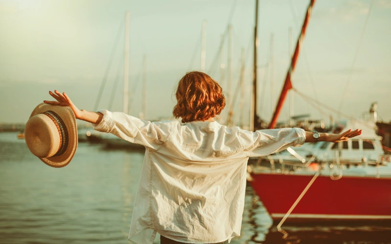 Mujer disfrutando de la libertad frente al mar en un club náutico