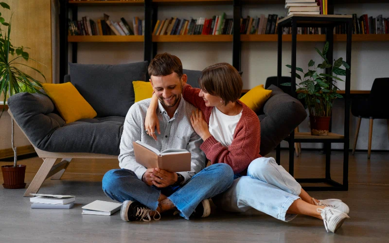 Pareja disfrutando de un libro en su salón