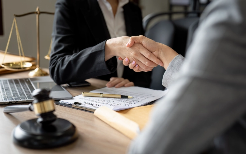 Juez y cliente estrechándose la mano tras un asesoramiento legal