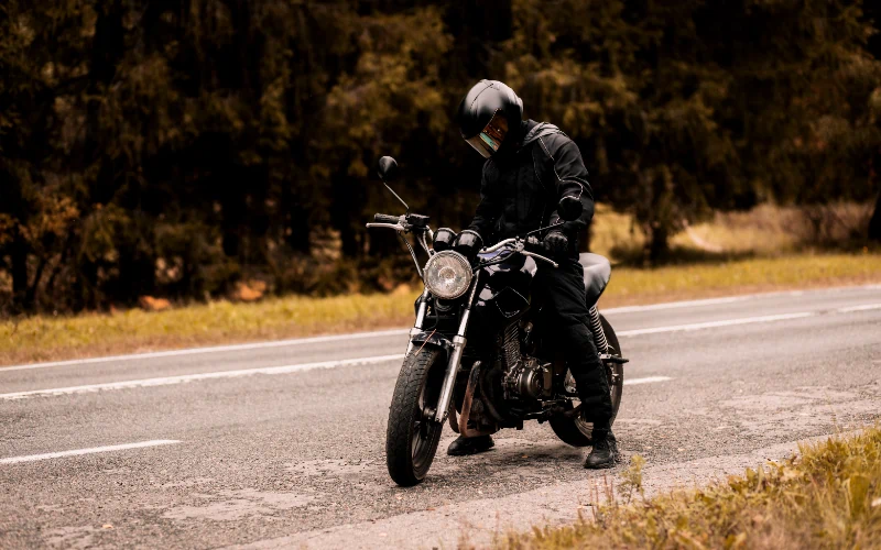 Motorista con casco junto a su moto café racer