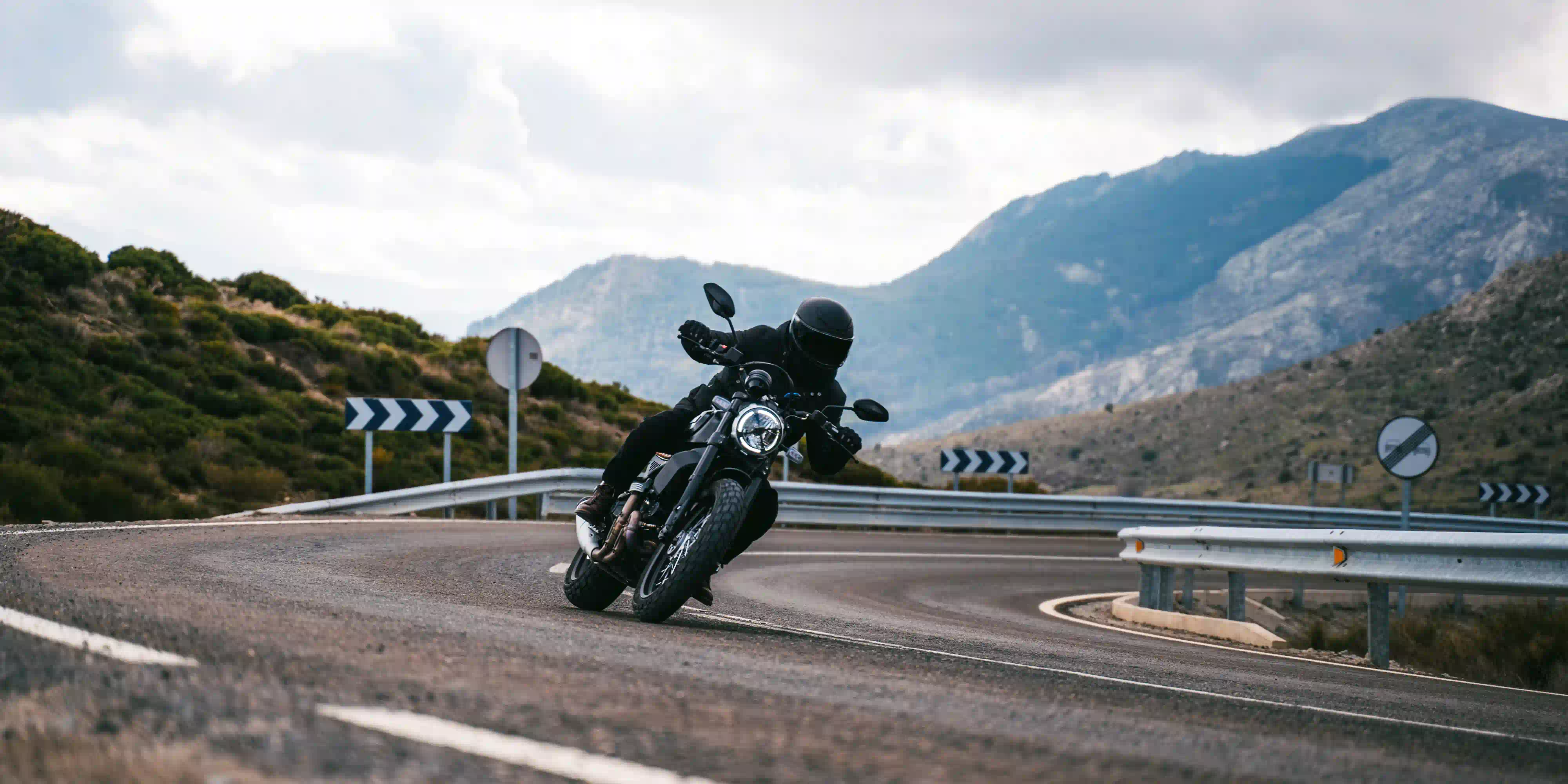 Motorista tomando una curva en carretera de montaña