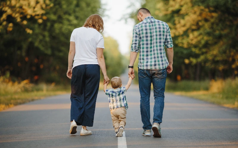 Padres paseando con su hijo pequeño de la mano