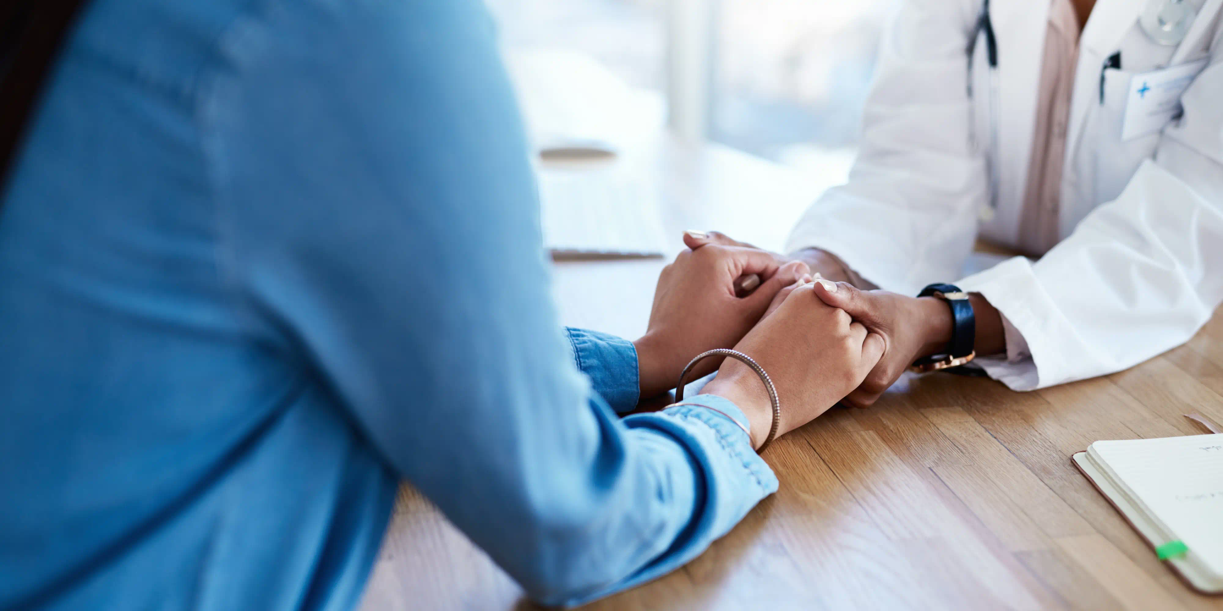 Médico cogiendo la mano de su paciente