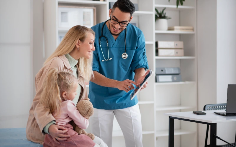Médico atendiendo en su consulta de pediatría
