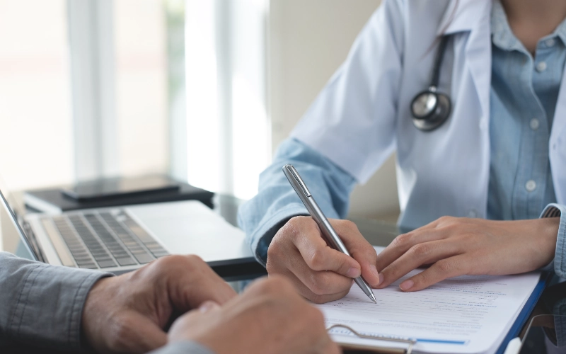 Médica rellenando una receta médica a su paciente