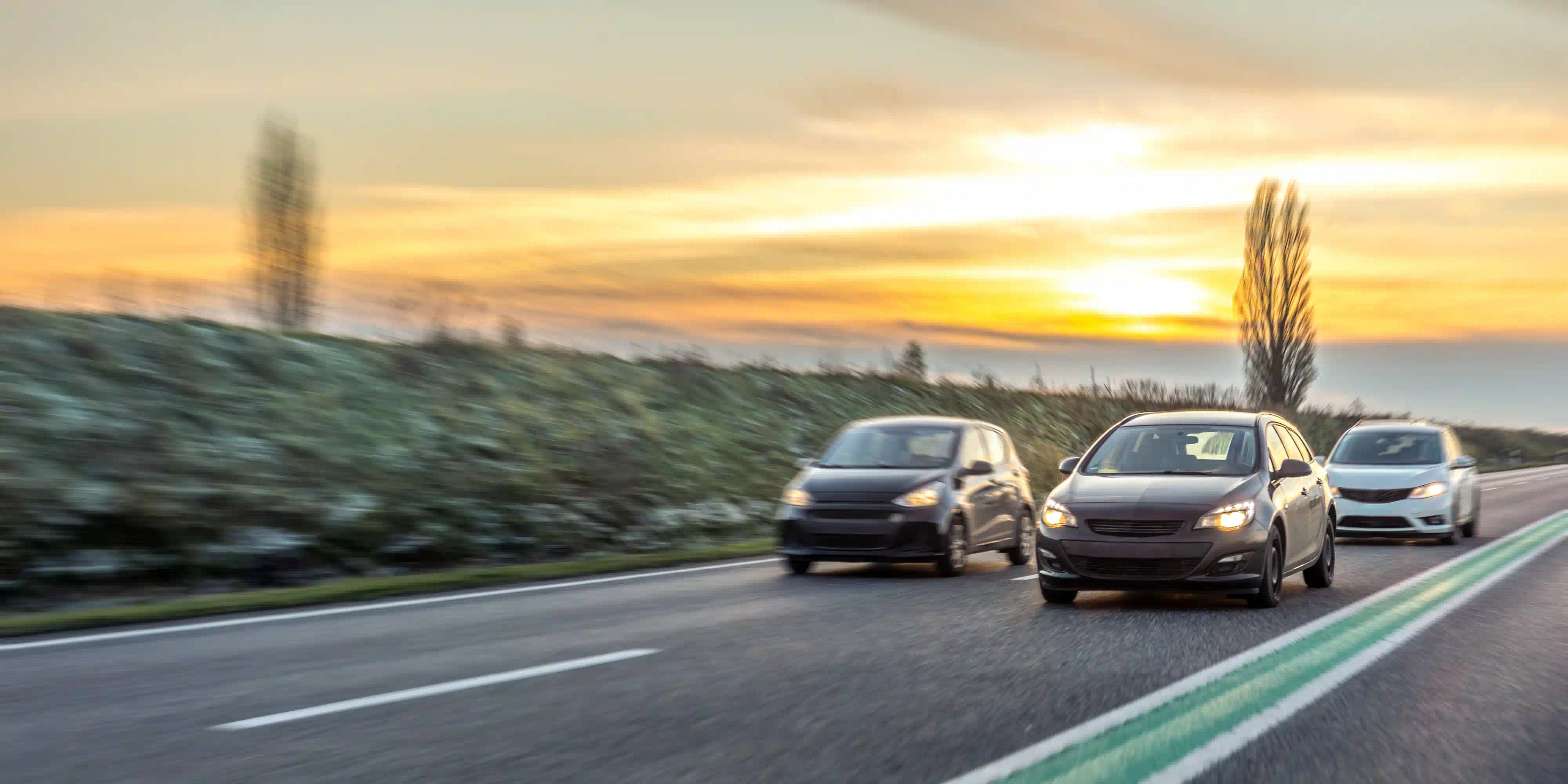 Coches circulando por autopista al atardecer