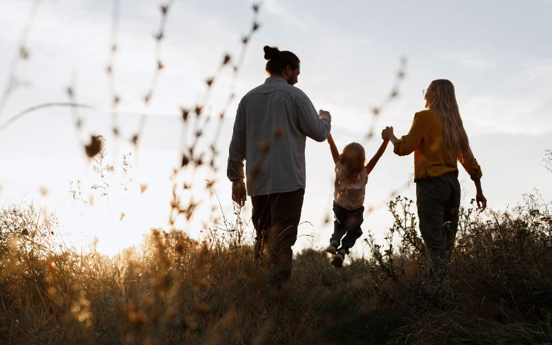 Familia caminando junto al mar al atardecer